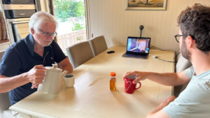 To menn drikker te forran videomøte