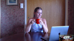 Jente foran en Mac. Hun drikker te.